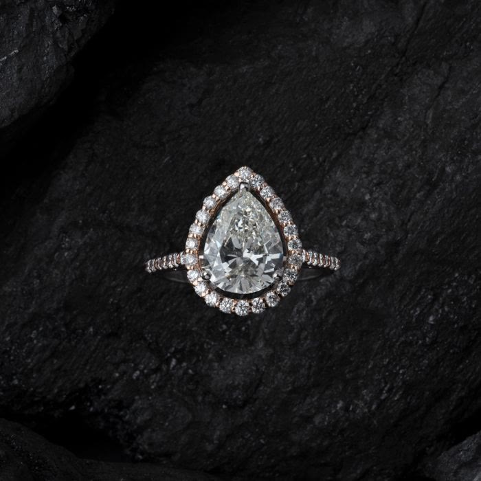 Anello con diamante a goccia su pietra scura